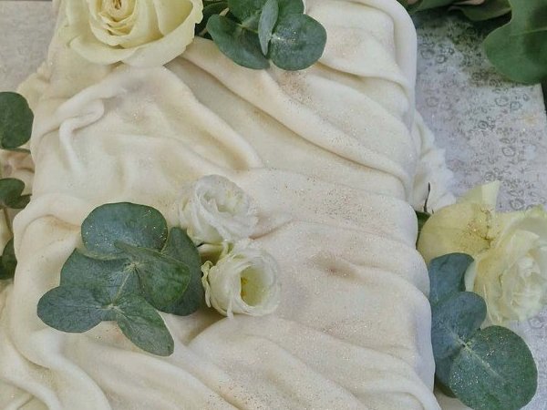 Bolo branco em pasta drapeada, com rosas brancas e eucalipto
