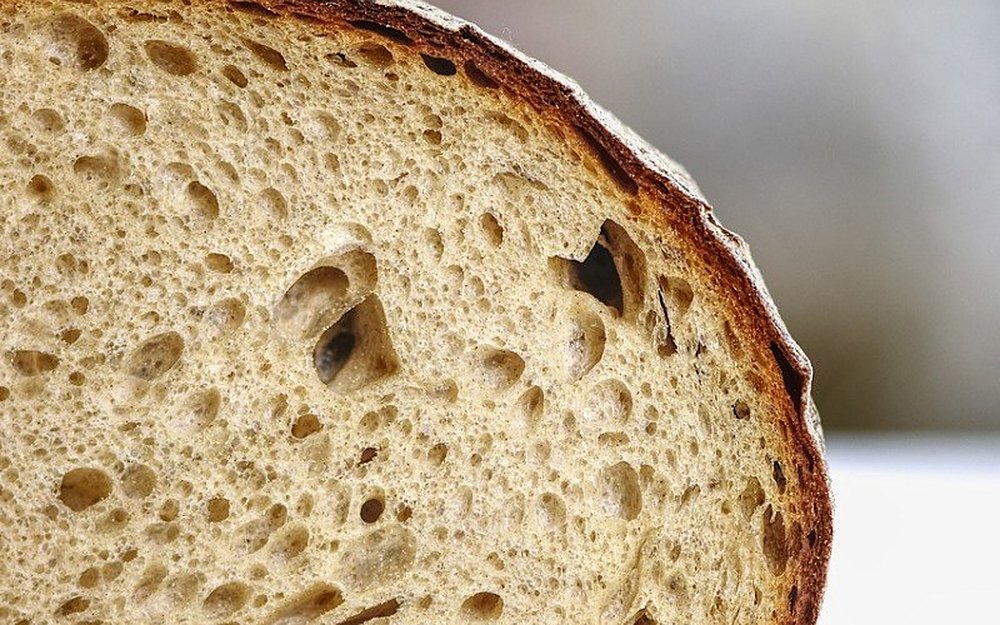 Pão cortado ao meio, com miolo alveolado e côdea escura